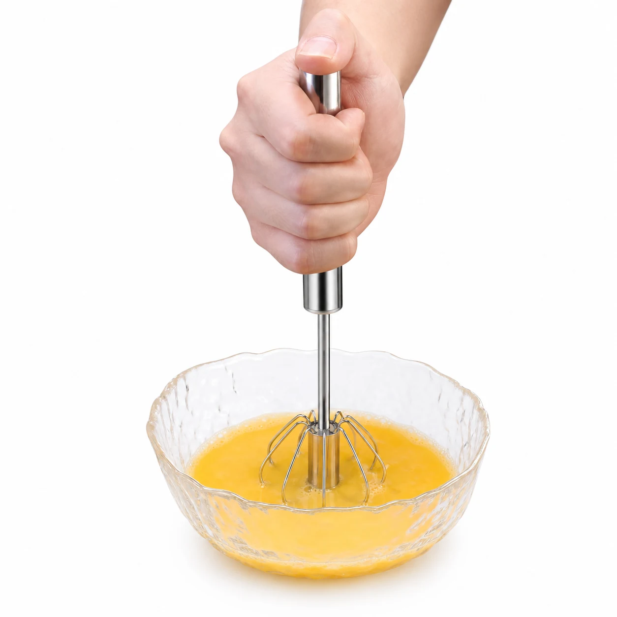 Press action stainless steel egg whisk mixing in a glass bowl